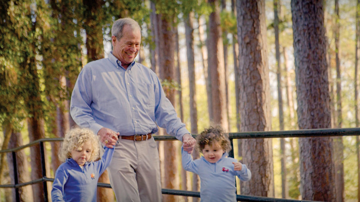 grandfather walking with two children
